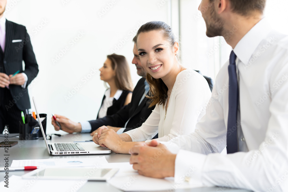 Portrait of a cheerful businesswoman sitting at the table in office and looking at camera. Portrait of a cheerful businesswoman sitting at the table in office and looking at camera.