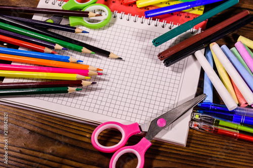 Different school stationeries on a dark wooden table