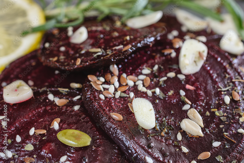 Baked beetroot sliced in slices with spice and slices of garlic next to a branch of rosemary Baked beetroot sliced in slices with spice and slices of garlic next to a branch of rosemary