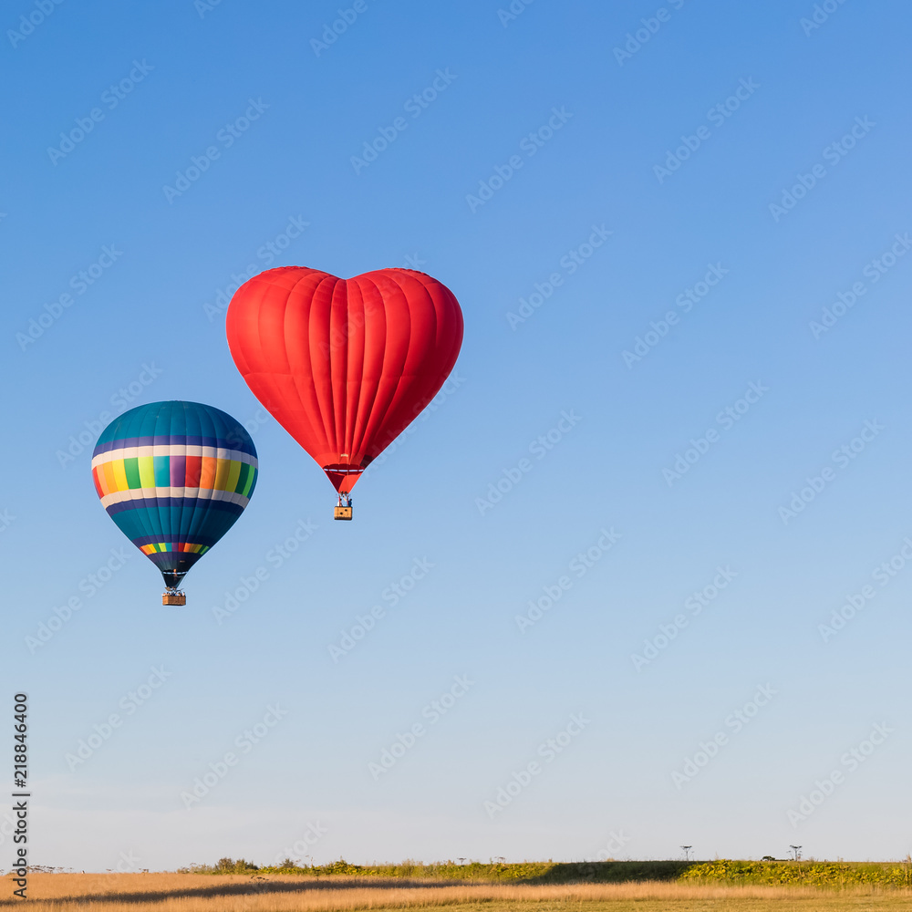 Naklejka premium Red heart shaped and colorful air balloons flying in the sky, banner