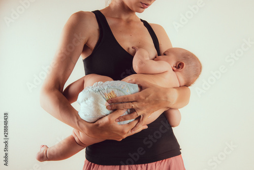 Happy mother with newborn baby infant on hands standing and breasfeeding lacting lactation health and care bonding time photo