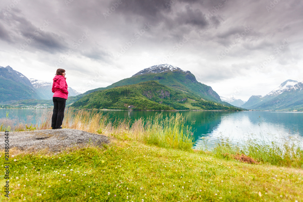 Woman tourist relaxing on fjord sea shore, Norway Woman tourist relaxing on fjord sea shore, Norway