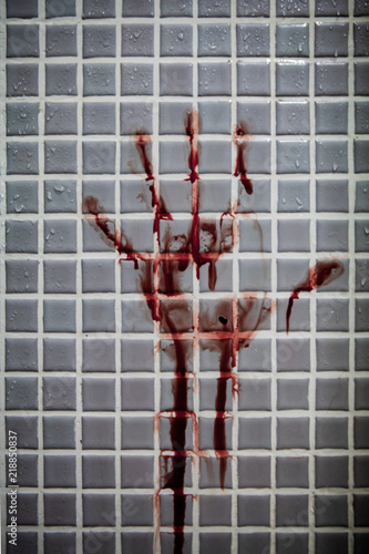 Old and dried out bloody handprint or bloodstains with streaks on wet bathroom tiles wall. Horror halloween or Violent crime or Homicide murder or Domestic violence concept.