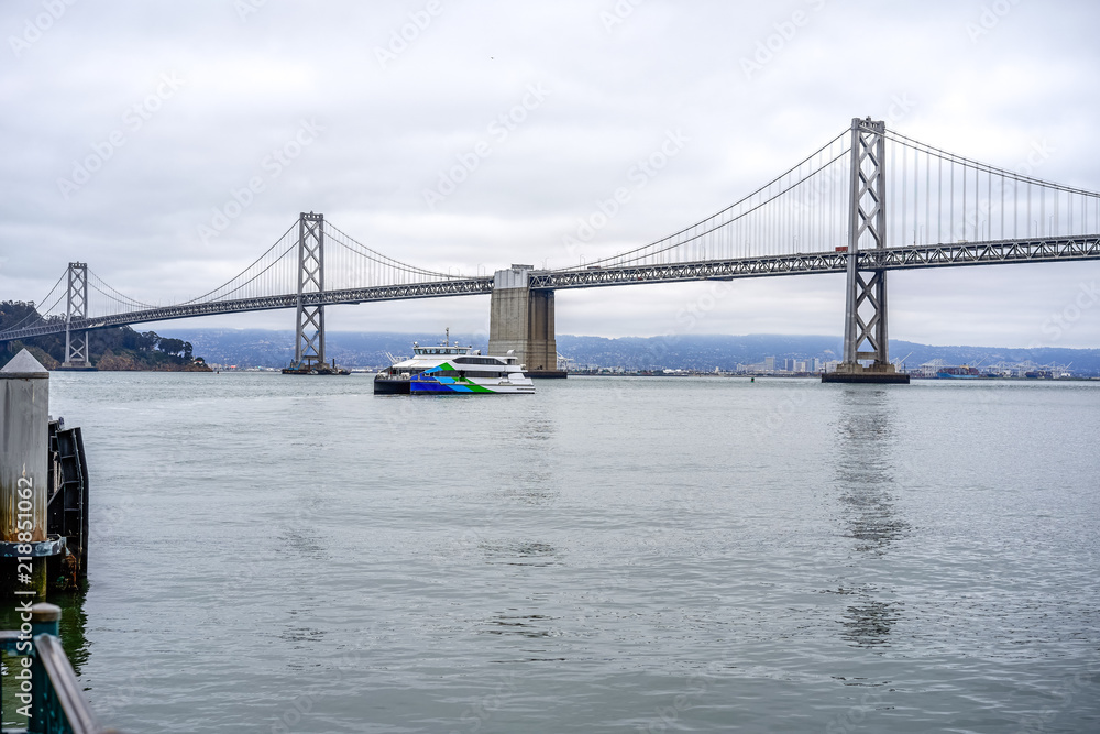 A ferry in the bay and a view of the bridge, San Francisco, USA