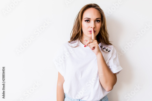 Young woman showing silence sign isolated on white