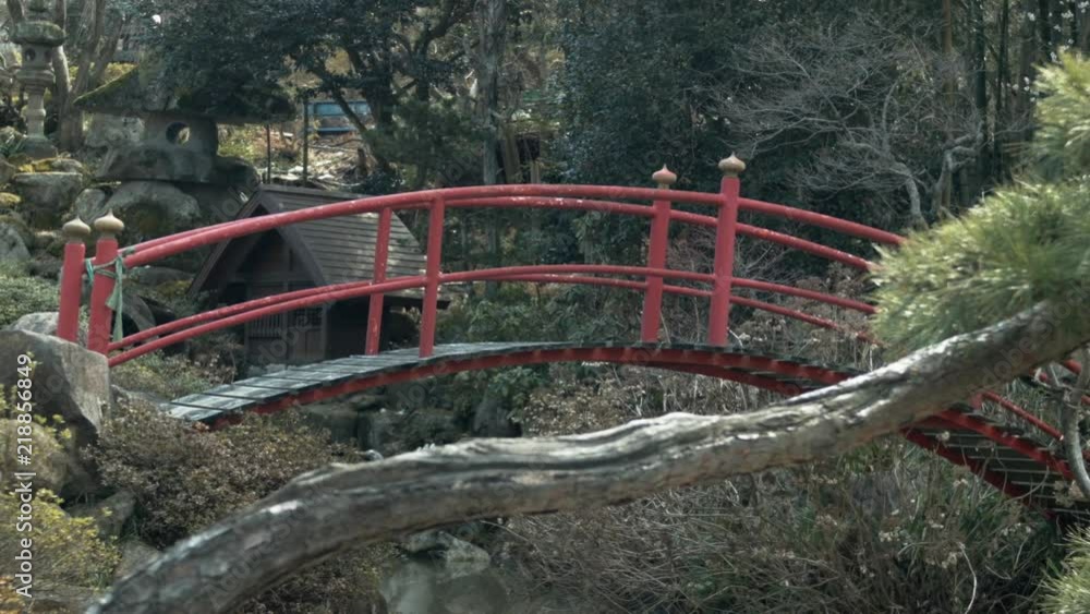 Red arched bridge over river near country road Red arched bridge over river near country road