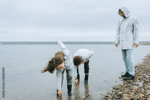 brother with sister have a fun in the sea wearing in raincoat photo