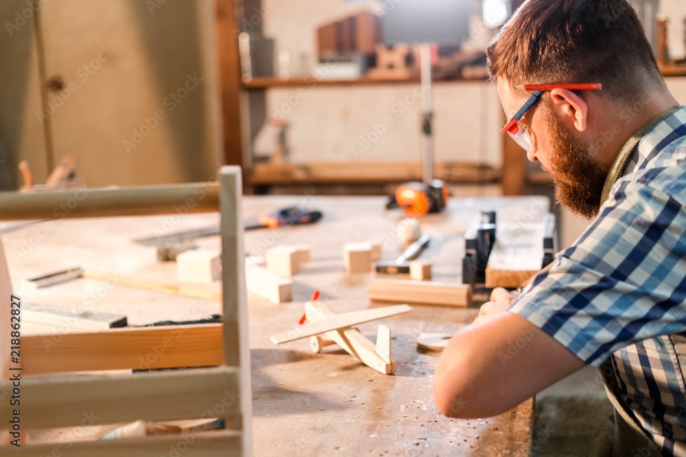Bearded carpenter doing carpentry at the workplace Bearded carpenter doing carpentry at the workplace