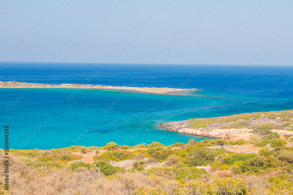 Beautiful beach of Crete with turquoise water. A popular tourist beach. Kolokitha beach. Peninsula Kalydon. Crete, Elounda,Greece. Beautiful beach of Crete with turquoise water. A popular tourist beach. Kolokitha beach. Peninsula Kalydon. Crete, Elounda,Greece.