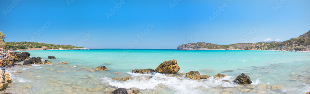 One of the best beaches on Crete, Greece. Voulisma beach near to Agios Nikolaos. Colorful beach with white sand and rocks. Tropical turquoise beach with blue sky. Summer 2018