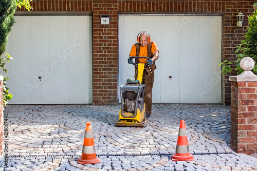 Builder or contractor laying new paving bricks. photo