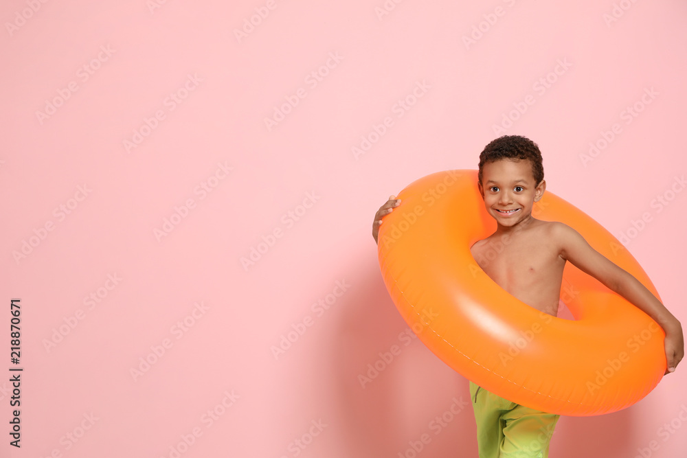 Fototapeta premium Cute African American boy with bright inflatable ring on color background
