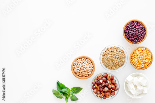 Vegan protein source. Legumes, nuts, cheese, spinach. Raw beans, chickpeas, lentil, almond, hazelnut on white background top view copy space