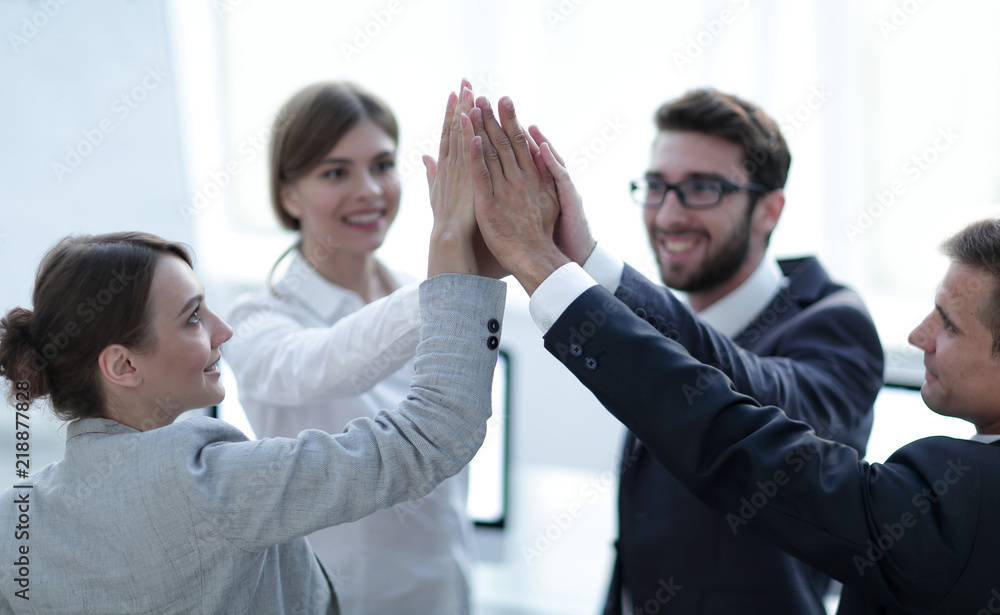 successful business team giving each other a high-five, standing in the office successful business team giving each other a high-five, standing in the office