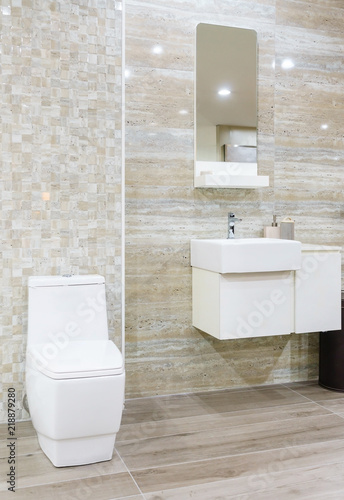 Modern spacious bathroom with bright tiles with toilet and sink.