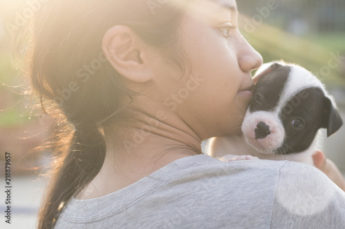 new born half french bulldog puppy looking on cute female asian Thai girl kid teen face while she talking with copy space pet and animal mental healthcare therapy concept