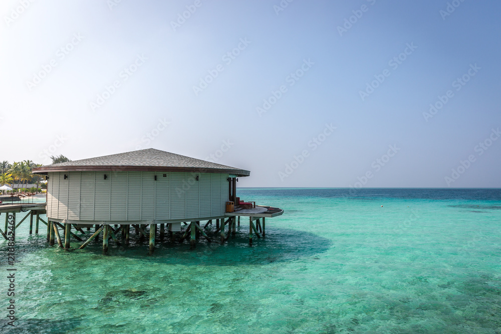 Maldives, Feb 8th 2018 - A part of the Cestara hotel over the blue water beach, calm waters in the lagoon in a clear sky in Maldives