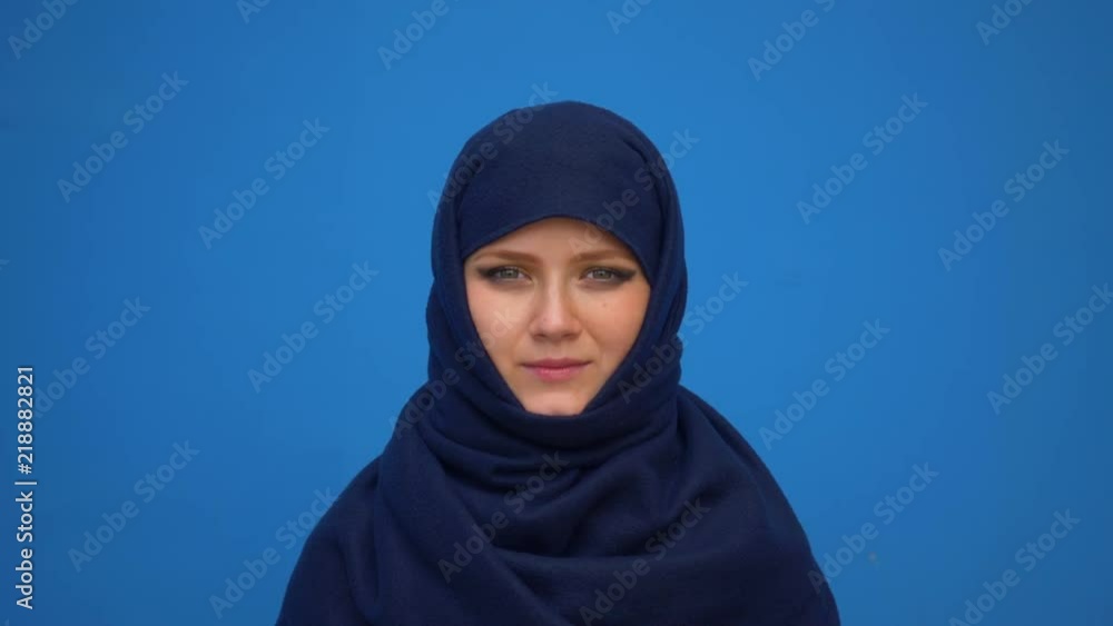 close up portrait of lovely young muslim business woman wearing hijab headscarf looking confident smiling calm professional ambitious over blue background close up portrait of lovely young muslim business woman wearing hijab headscarf looking confident smiling calm professional ambitious over blue background