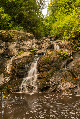 small waterfall rushing down in the forest