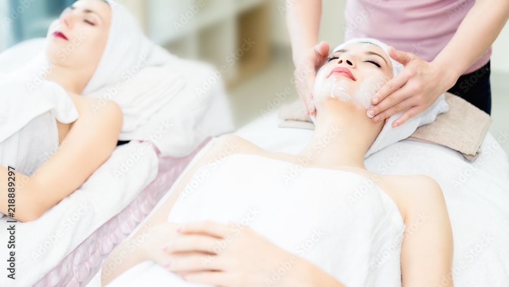 Woman lying in bed relaxing in spa.Woman is lying on the spa bed to do a facial scrub.Spa facial massage in beauty salon. Woman lying in bed relaxing in spa.Woman is lying on the spa bed to do a facial scrub.Spa facial massage in beauty salon.