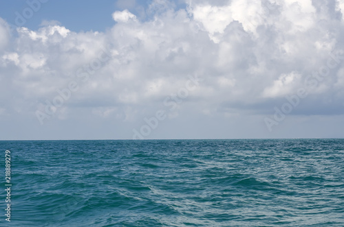 Smooth sea surface against a background of a cloudy sky.