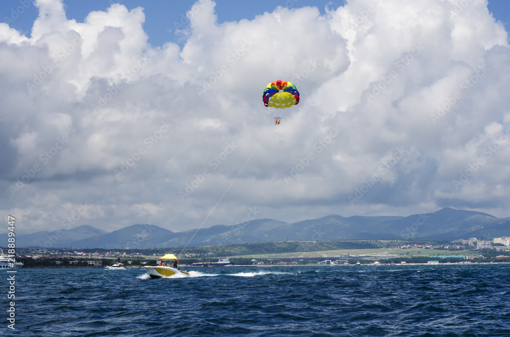 Boat with a floating parachute on a rope leaving into the sea. Boat with a floating parachute on a rope leaving into the sea.