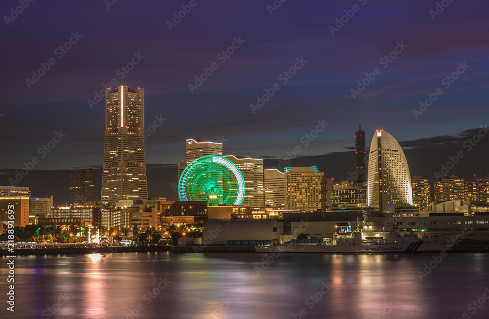 Naklejka premium Cosmo Clock Big Wheel at Cosmo World Theme Park, Landmark Tower and Pacifico Yokohama Hall overlooking the Red Brick Warehouse and Tourist boat terminal in the Minato Mirai district of Yokohama.