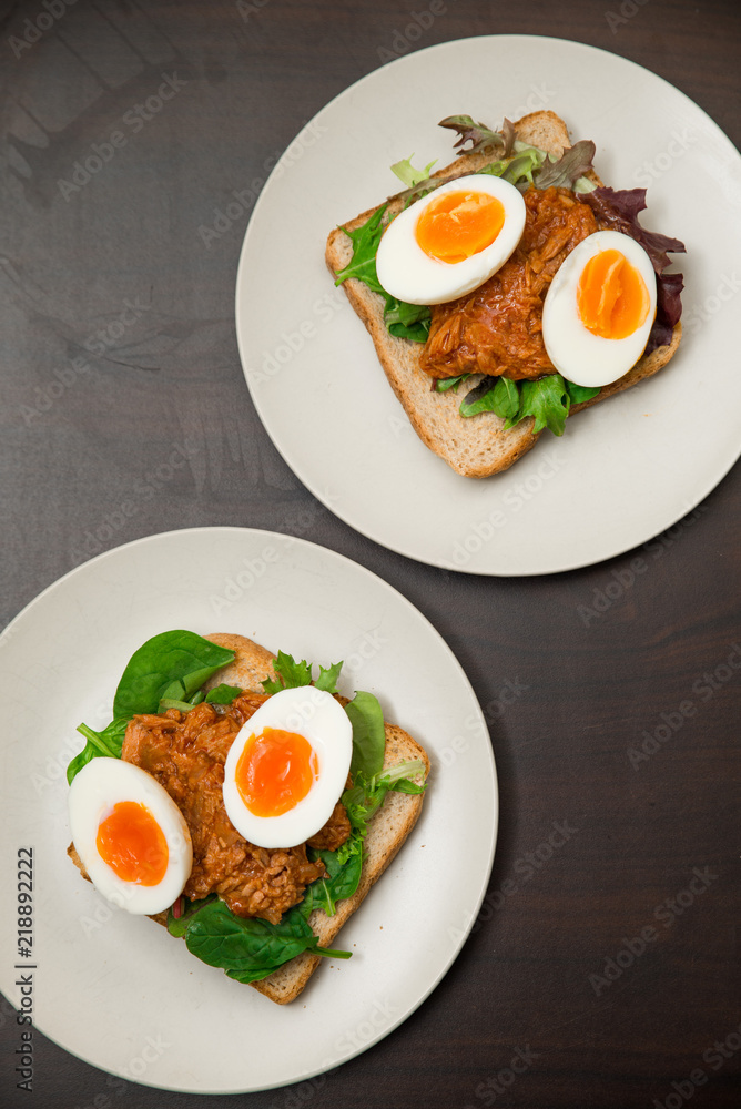 Healthy natural high protein snack whole grain toast with soft boiled egg, tuna and spinach Healthy natural high protein snack whole grain toast with soft boiled egg, tuna and spinach
