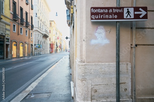Wall Mural Rome,Italy-July 29 2018: Directional arrow for Trevi Fountain displayed at the c
