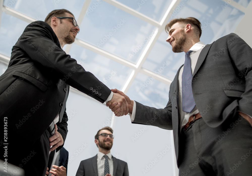 bottom view.smiling business people shaking hands bottom view.smiling business people shaking hands