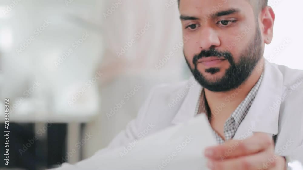 Happy doctor reads results of medical examination patient and sees good results of treatment. Doctor is pleased to recovery of patient Happy doctor reads results of medical examination patient and sees good results of treatment. Doctor is pleased to recovery of patient