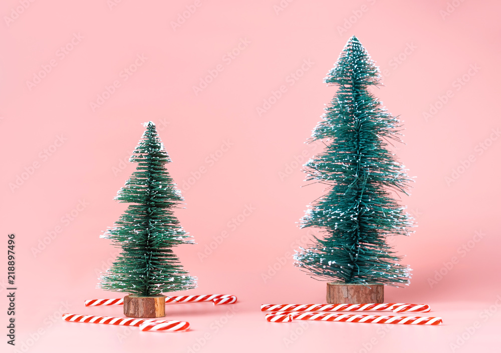 Christmas tree with candy cane on pastel pink studio background.Holiday festive celebration greeting card with copy space to addng text. Christmas tree with candy cane on pastel pink studio background.Holiday festive celebration greeting card with copy space to addng text.
