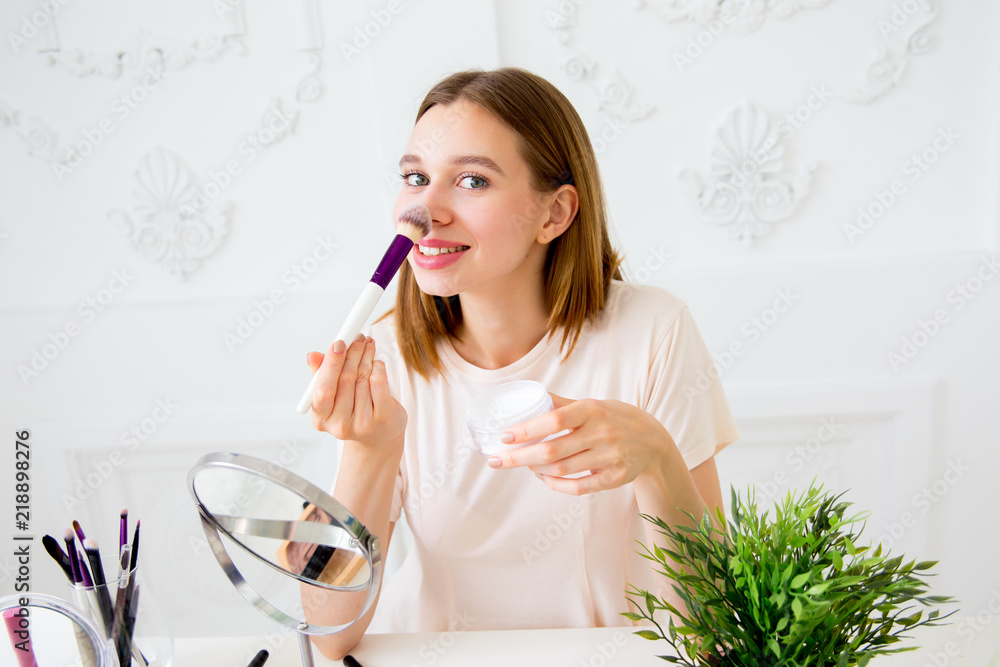 A portrait of woman with makeup brushes near face A portrait of woman with makeup brushes near face