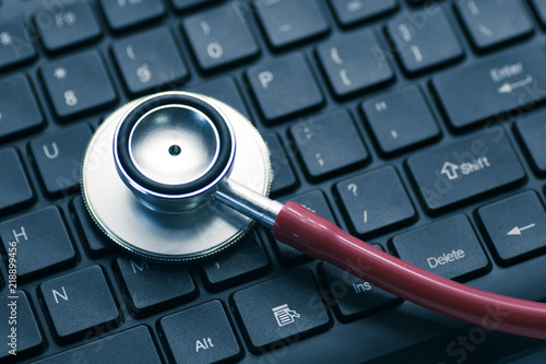 red doctor stethoscope on black computer keyboard with copy space for text, technology health check concept