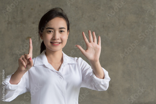 asian business woman pointing six fingers; portrait of positive happy smiling asian businesswoman pointing up six fingers, 6 points number list; asian chinese 20s young adult woman model