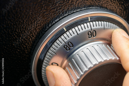 Close-up of hand searching security code of safe.