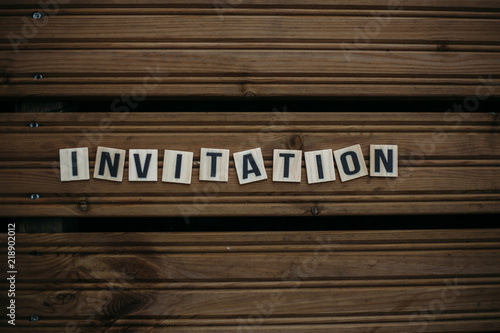 Invitation. Text on a wooden background