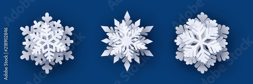 Vector set of 3 white Christmas paper cut 3d snowflakes with shadow on dark blue background. New year and Christmas design elements