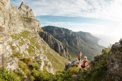 Two trail runners enjoying the view of Table Mountain and the ocean in Cape Town South Africa
