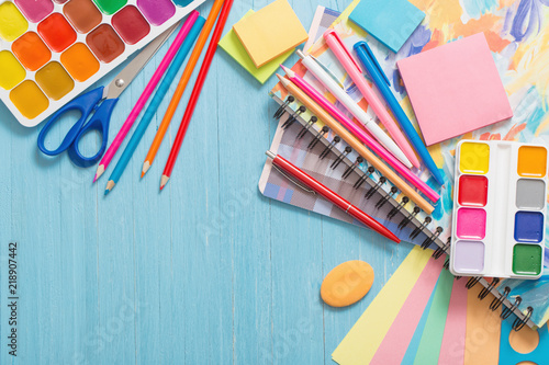 Collection of school supplies on blue wooden background photo