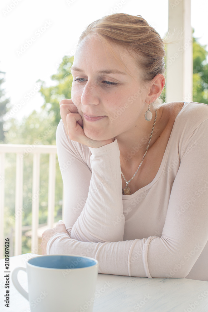 Mädchen nachdenklich beim Kaffee trinken auf ihrer Veranda Mädchen nachdenklich beim Kaffee trinken auf ihrer Veranda