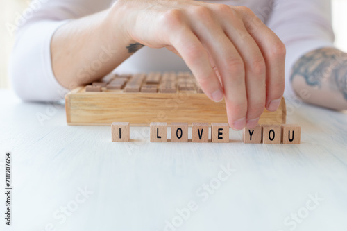 Girl writing I love you with wooden cubes-Valentine card motive photo