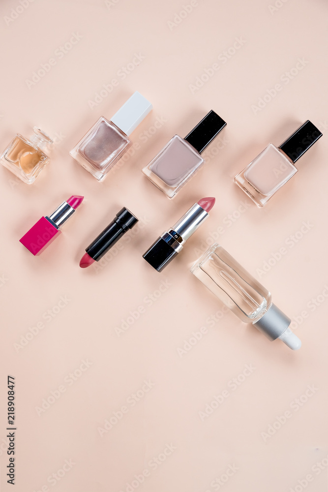 Obraz premium Colorful frame with various makeup products on pastel background. cosmetics, skin care, perfume, nail Polish, lipstick flat lay and skin oil bottle over a beige background.Beauty products concept.Copy