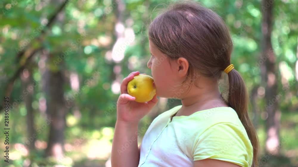 Sweet having fun outdoor girl eating an red apple in a park in nature. Sweet having fun outdoor girl eating an red apple in a park in nature.