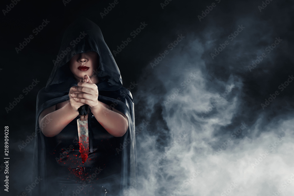 Witch woman holding a bloody knife with smoky background