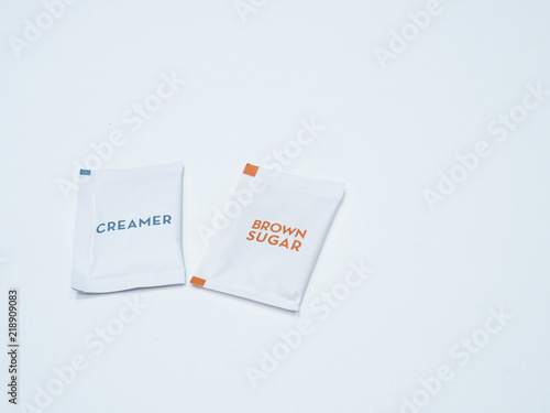 The white paper package of creamer and brown sugar for hot coffee and tea.