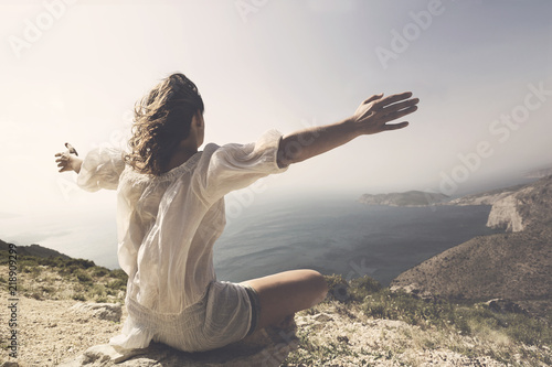 woman taking a breath in front of a spetacular view photo