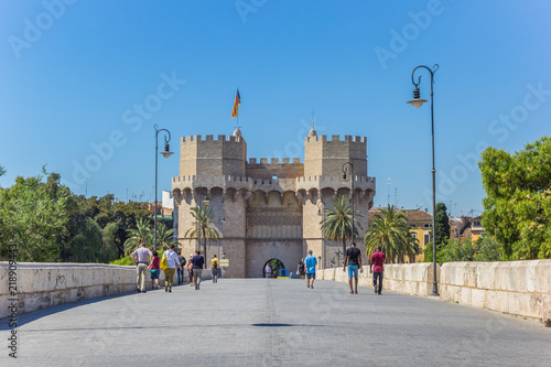 People walking the Serranos brigde towards the historic city gate in Valencia, Spain photo