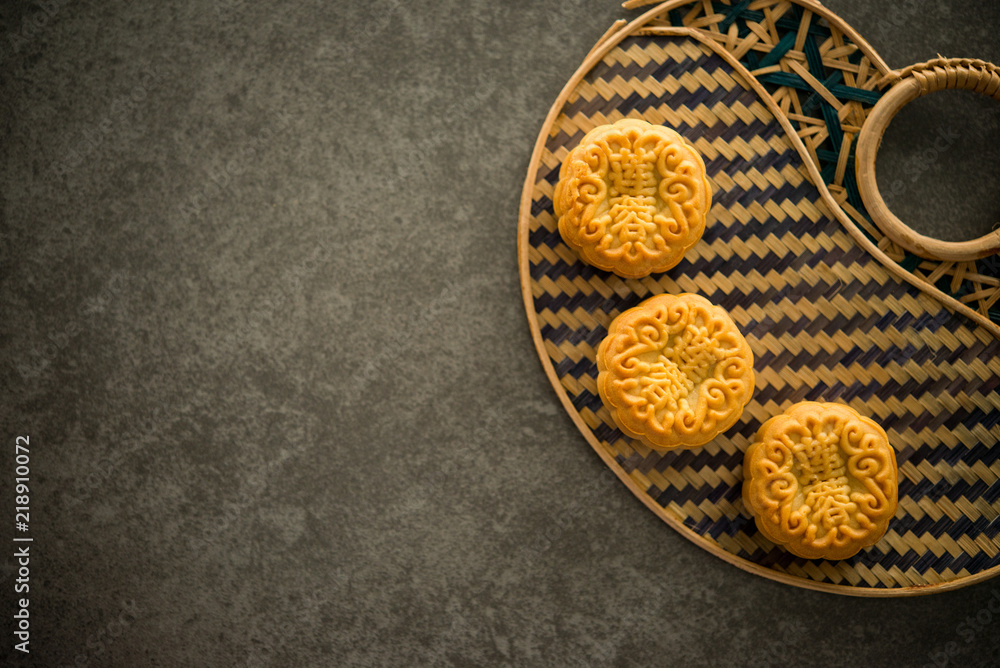 Mooncakes on bamboo background low light with copyspace Mooncakes on bamboo background low light with copyspace
