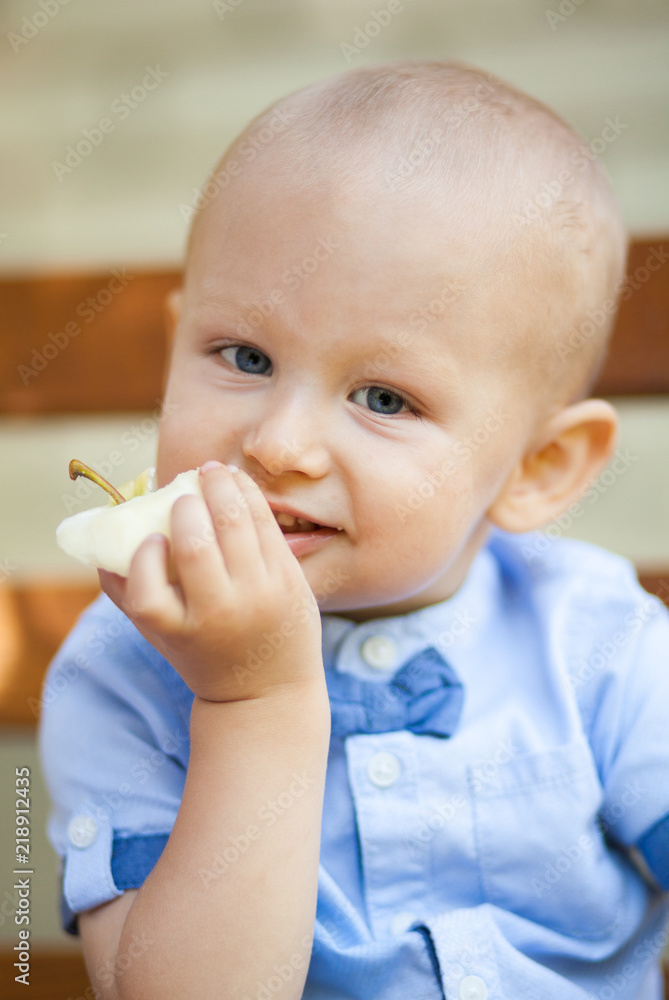 Portrait Of Baby Boy Eating green Apple. Active Cute boy eating green apple. Portrait Of Baby Boy Eating green Apple. Active Cute boy eating green apple.